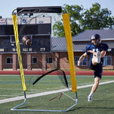 A man in athletic wear strikes a football in front of a goal net.